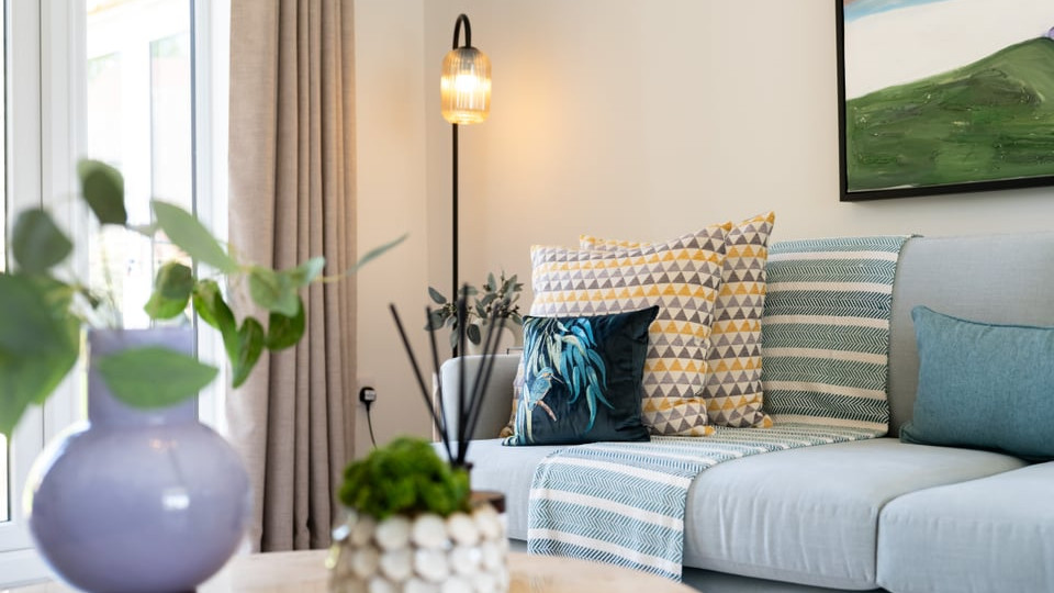 Interior view of a powder blue sofa in the lounge coffee table and French doors to garden.
